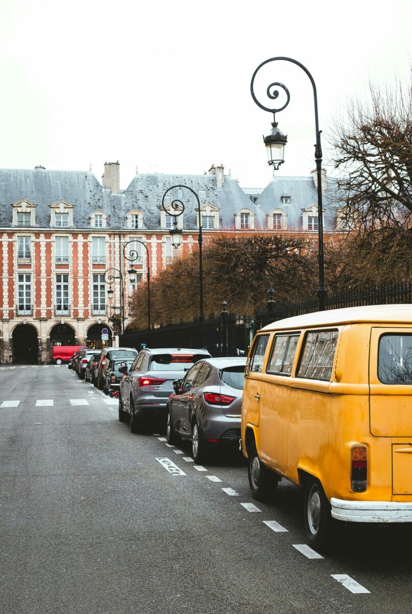 Une rue avec un passage piéton et des voitures garées.